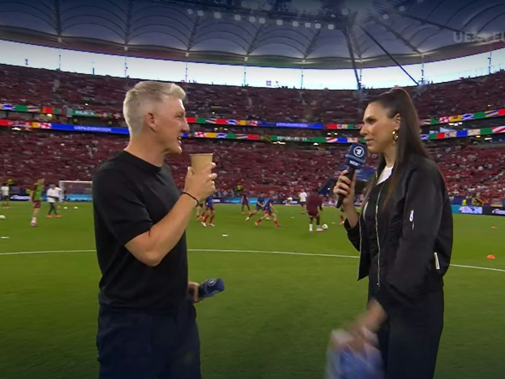 Bastian Schweinsteiger verwechselte beim Spiel Deutschland gegen die Schweiz das Mikro mit einem Kaffeebecher.