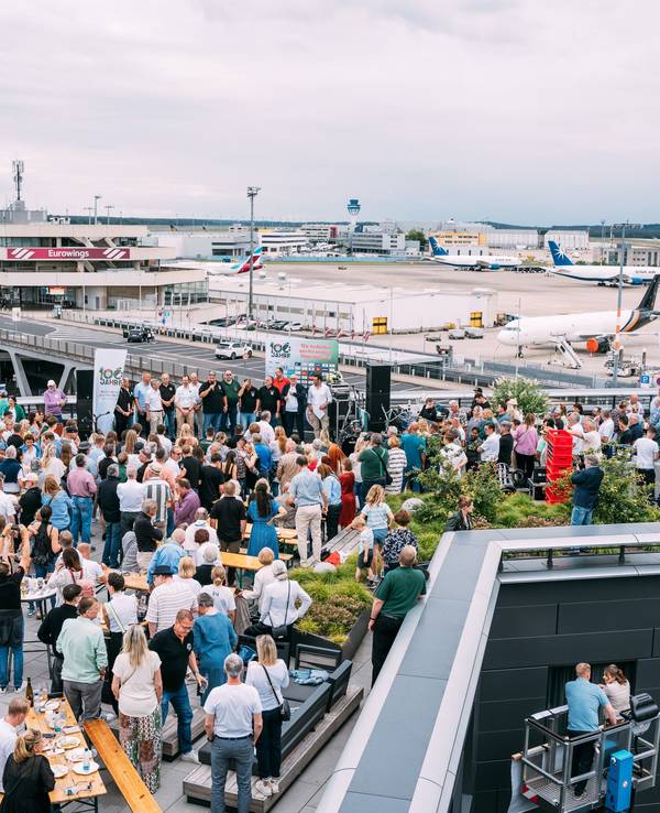 Viele Menschen auf der Dachterrassen eines Hotels am Flughafen Köln/Bonn. Im Hintergrund sind Flugzeuge zu sehen.