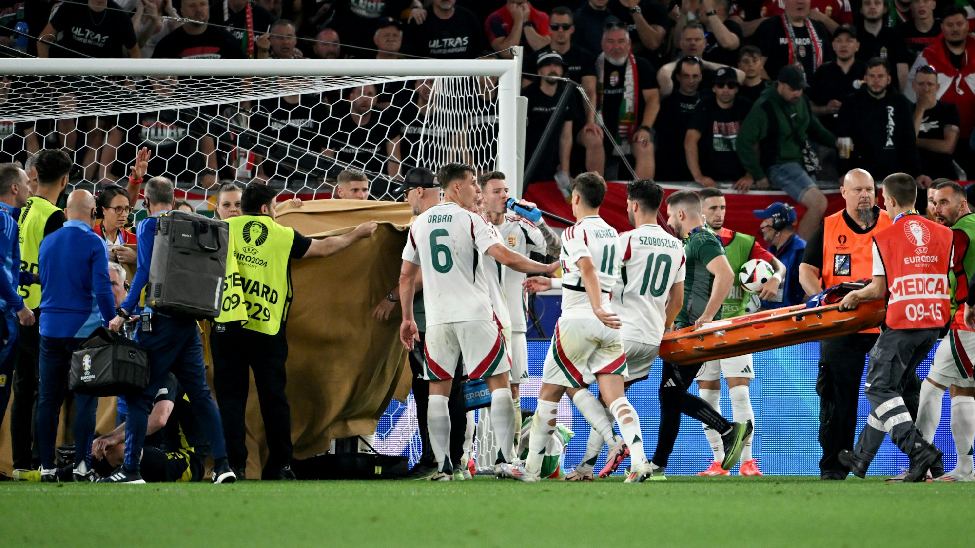 Nach einem Zusammenprall wird Ungarns Barnabas Varga hinter Sichtdecken behandelt.