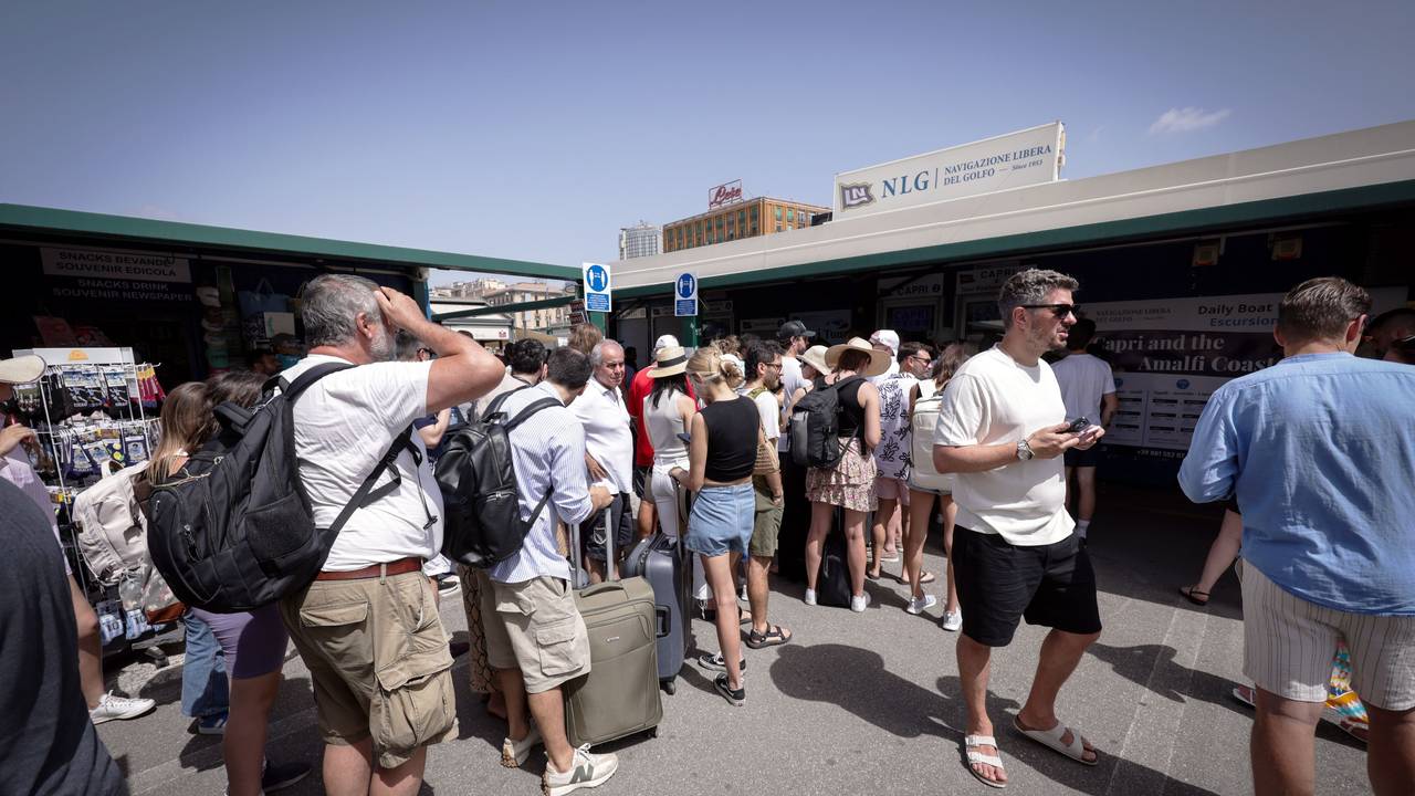 Reisende warten am Hafen von Neapel in einer Schlange vor den Ticketschaltern nach Capri. Touristinnen und Touristen durften wegen Problemen mit der Trinkwasserversorgung seit Samstagmorgen (22. Juni 2024) nicht mehr auf der italienischen Mittelmeerinsel an Land gehen. Am Sonntag wurde das Verbot aufgehoben.