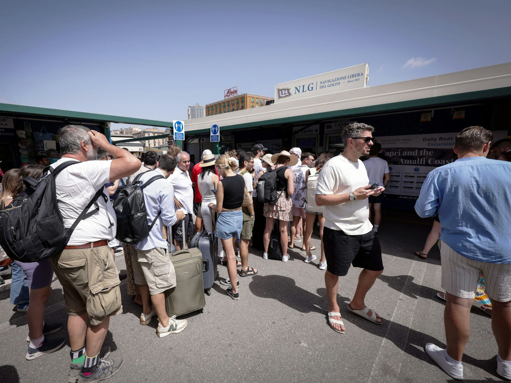 Reisende warten am Hafen von Neapel in einer Schlange vor den Ticketschaltern nach Capri. Touristinnen und Touristen durften wegen Problemen mit der Trinkwasserversorgung seit Samstagmorgen (22. Juni 2024) nicht mehr auf der italienischen Mittelmeerinsel an Land gehen. Am Sonntag wurde das Verbot aufgehoben.