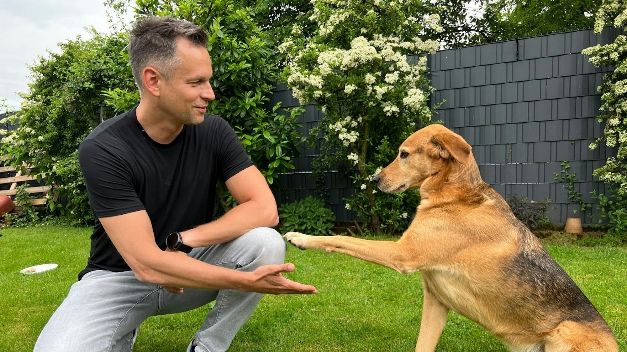Daniel Joeres mit Hund Theo im Garten von Autorin Stefanie Monien am 15. Mai 2024