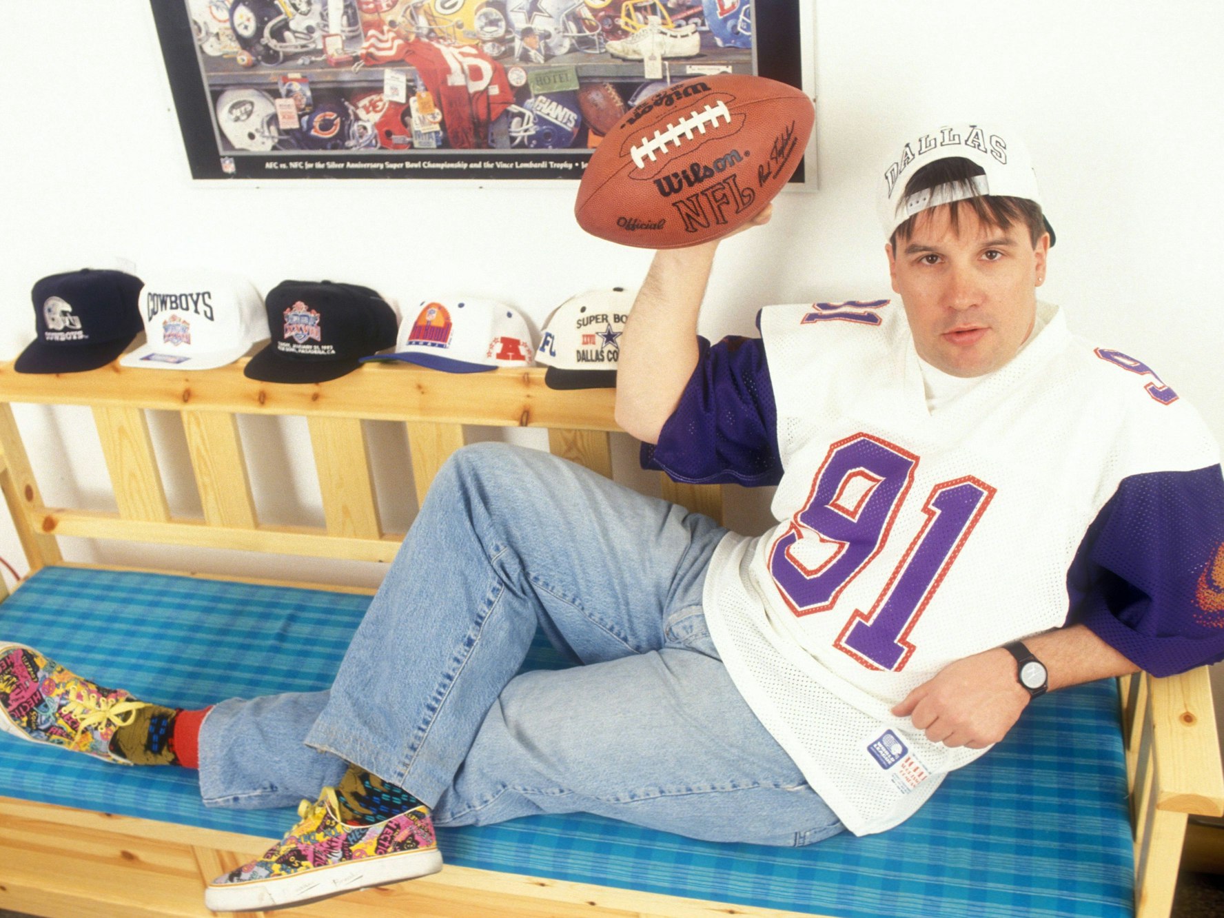 Günter Zapf im Football-Trikot mit einem Football auf einer Sitzbank.