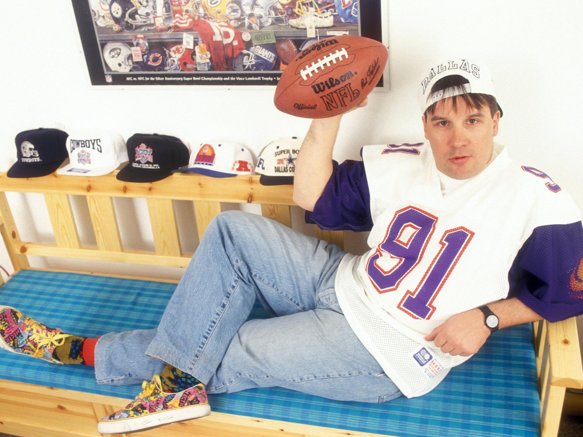 Günter Zapf im Football-Trikot mit einem Football auf einer Sitzbank.