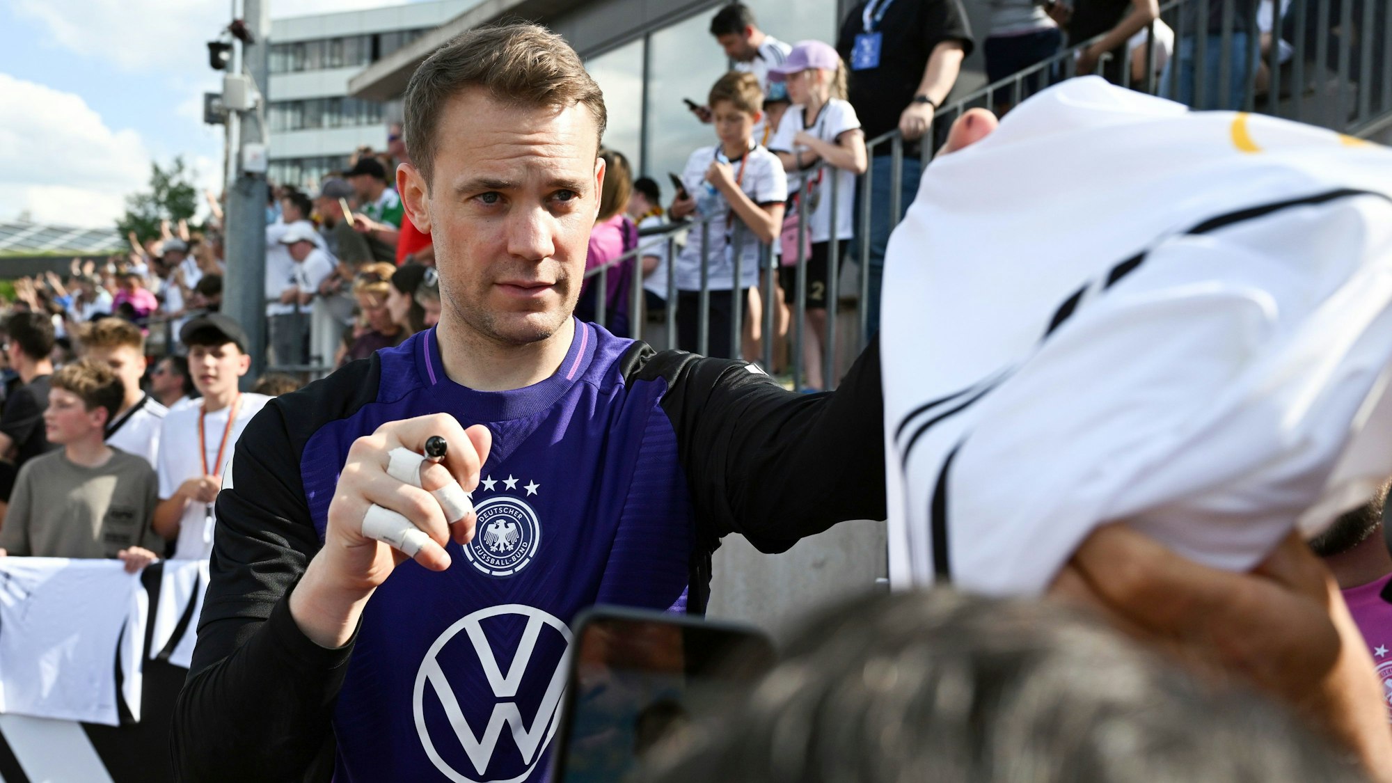 Deutschlands Torwart Manuel Neuer gibt während des öffentlichen Trainings im Adi-Dassler-Stadion Autogramme.