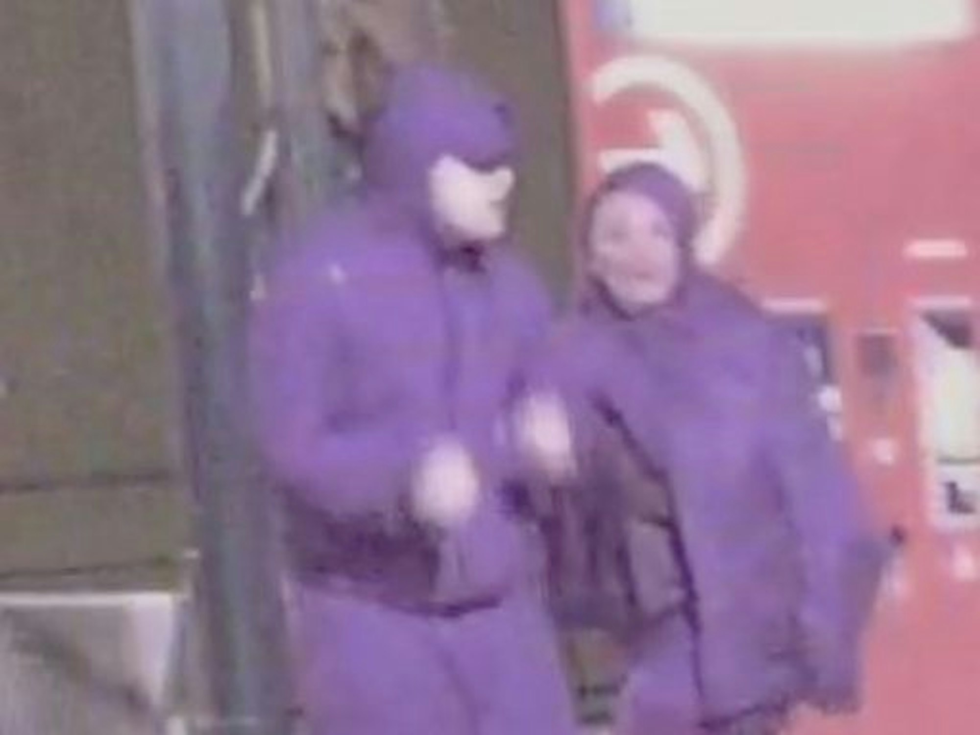 Ein Mann und eine Frau in violetten Outfits an einer KVB-Station.