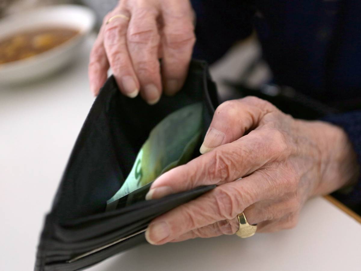 Eine Rentnerin öffnet ihr Portemonnaie