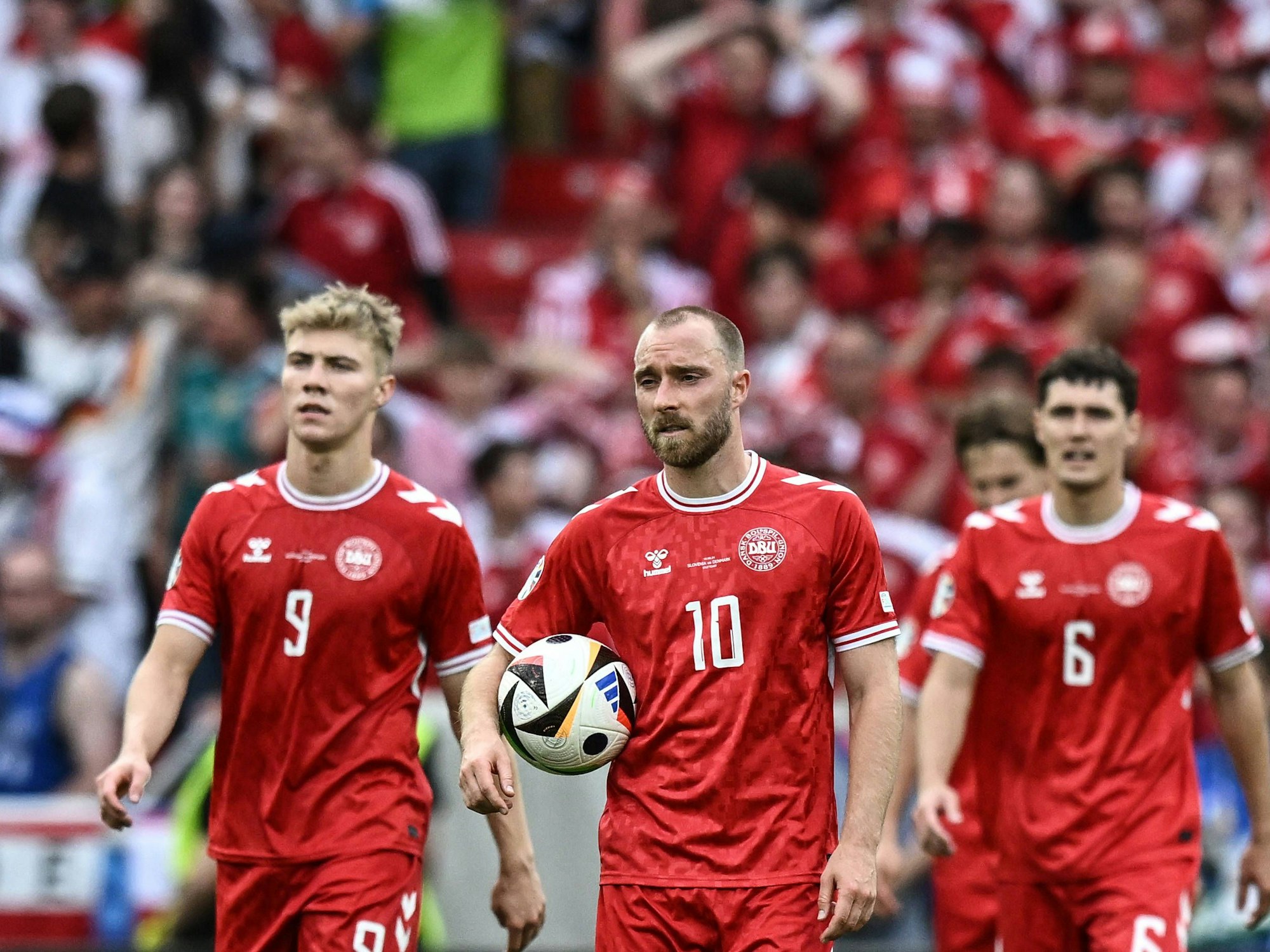 Christian Eriksen mit dem Ball in der Hand nach dem Ausgleichstor von Gegner Slowenien beim EM-Gruppenspiel. Links von ihm Teamkollege Rasmus Höjlund, rechts Andreas Christensen.