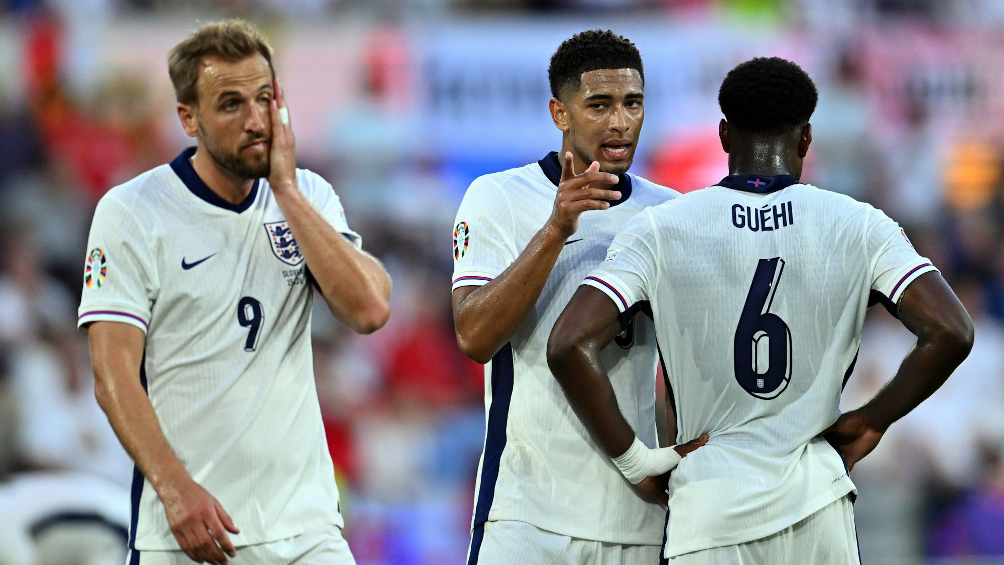 Englands Harry Kane (l-r), Englands Jude Bellingham und Englands Marc Guehi reagieren auf dem Platz.
