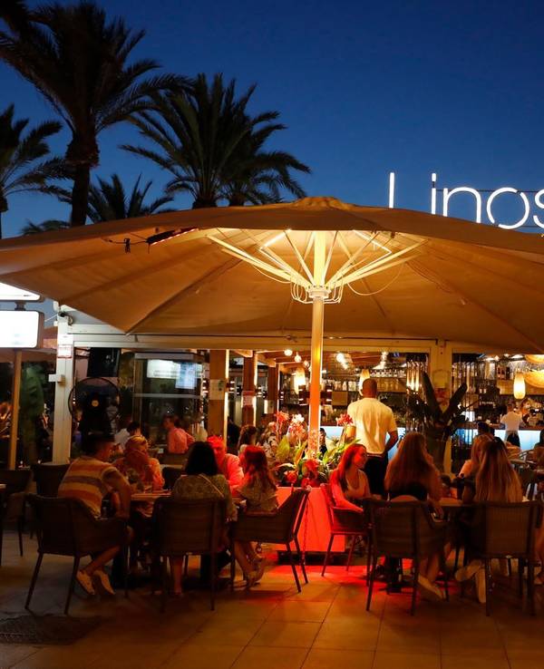 Menschen sitzen in einer Bar an der Strandpromenade von Palma (Mallorca).