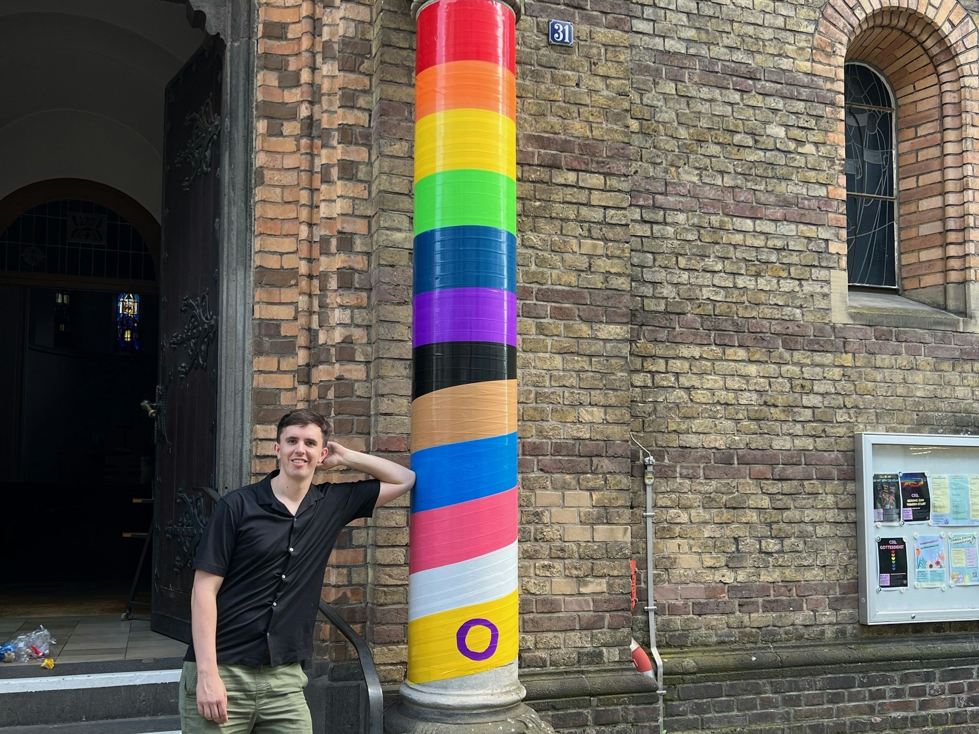 Pfarrer Tim Lahr steht neben einer geschmückten Säule an seiner Kirche.