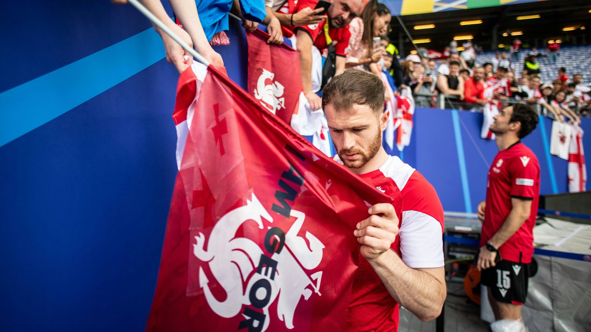 Budu Zivzivadze unterschreibt nach einem Georgien-Spiel bei der EM 2024 eine Fahne.