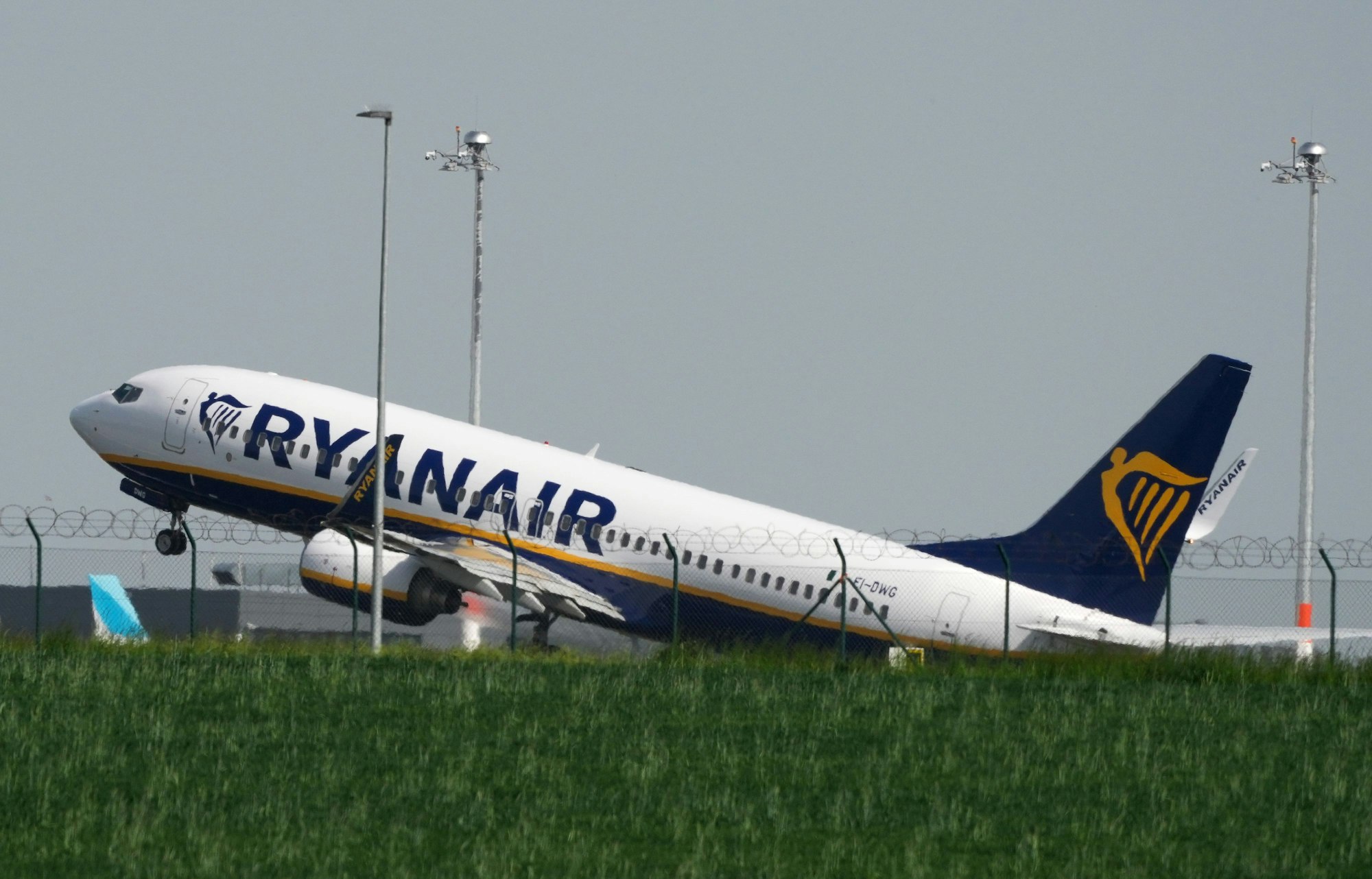 Eine Boeing 737 der Fluggesellschaft Ryanair startet hinter einer grünen Wiese vom Flughafen Berlin-Brandenburg (BER) „Willy Brandt“, hier im Mai 2023.