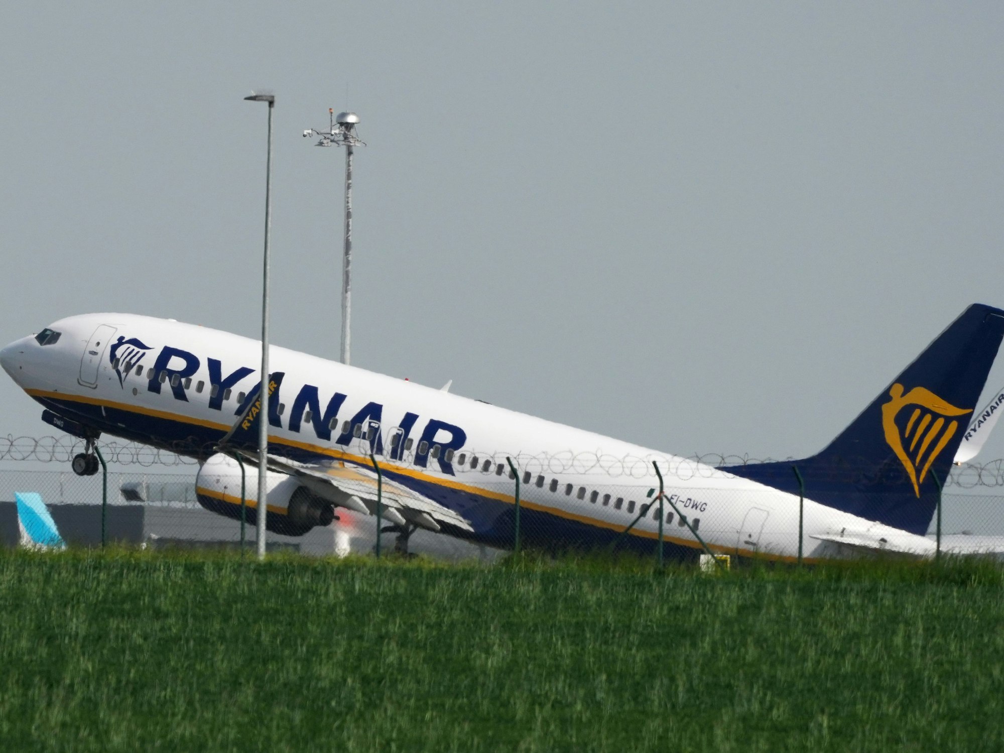 Eine Boeing 737 der Fluggesellschaft Ryanair startet hinter einer grünen Wiese vom Flughafen Berlin-Brandenburg (BER) „Willy Brandt“, hier im Mai 2023.