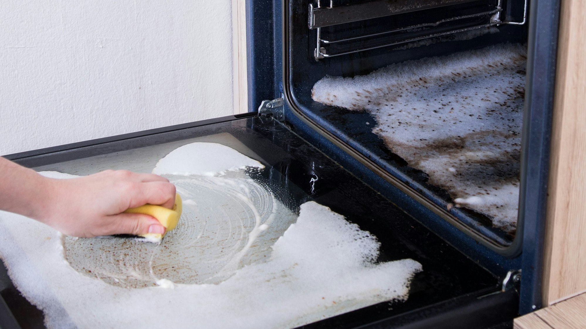 Ein verdreckter Backofen wird von innen gereinigt