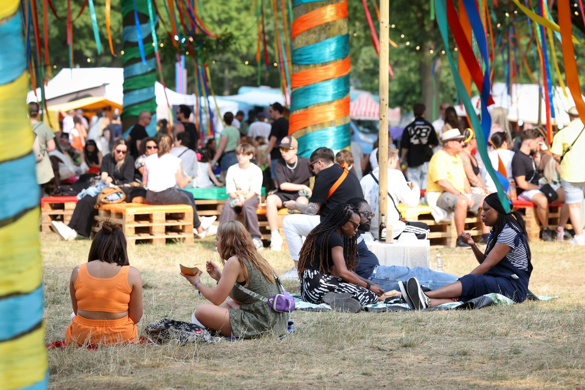 Menschen sitzen beim Summerjam-Festival auf dem Boden.
