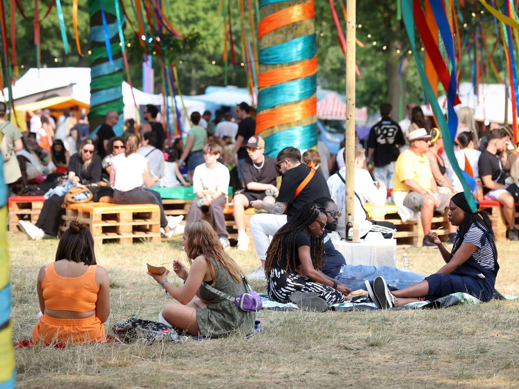 Menschen sitzen beim Summerjam-Festival auf dem Boden.