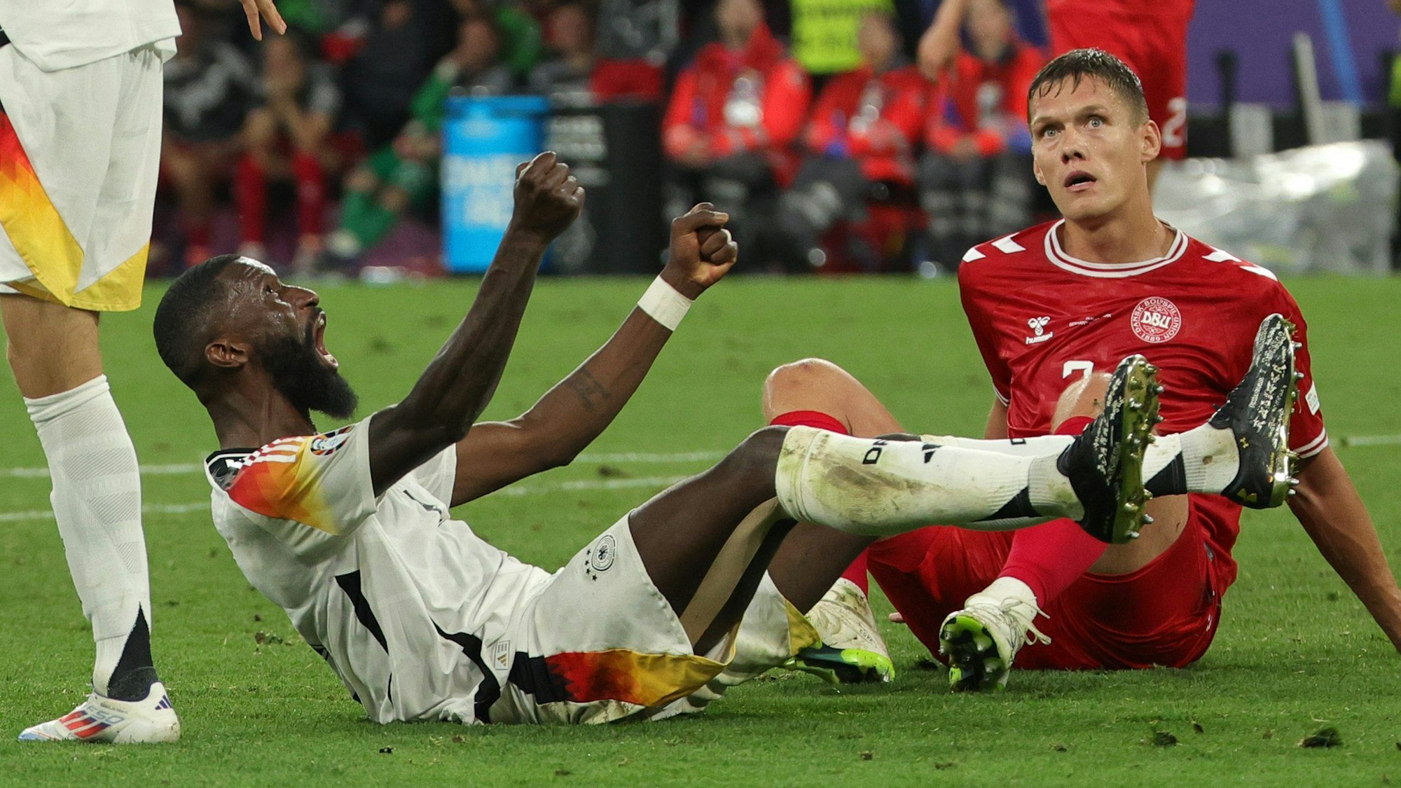 Deutschlands Antonio Rüdiger (l) sitzt jubelnd auf dem Platz.