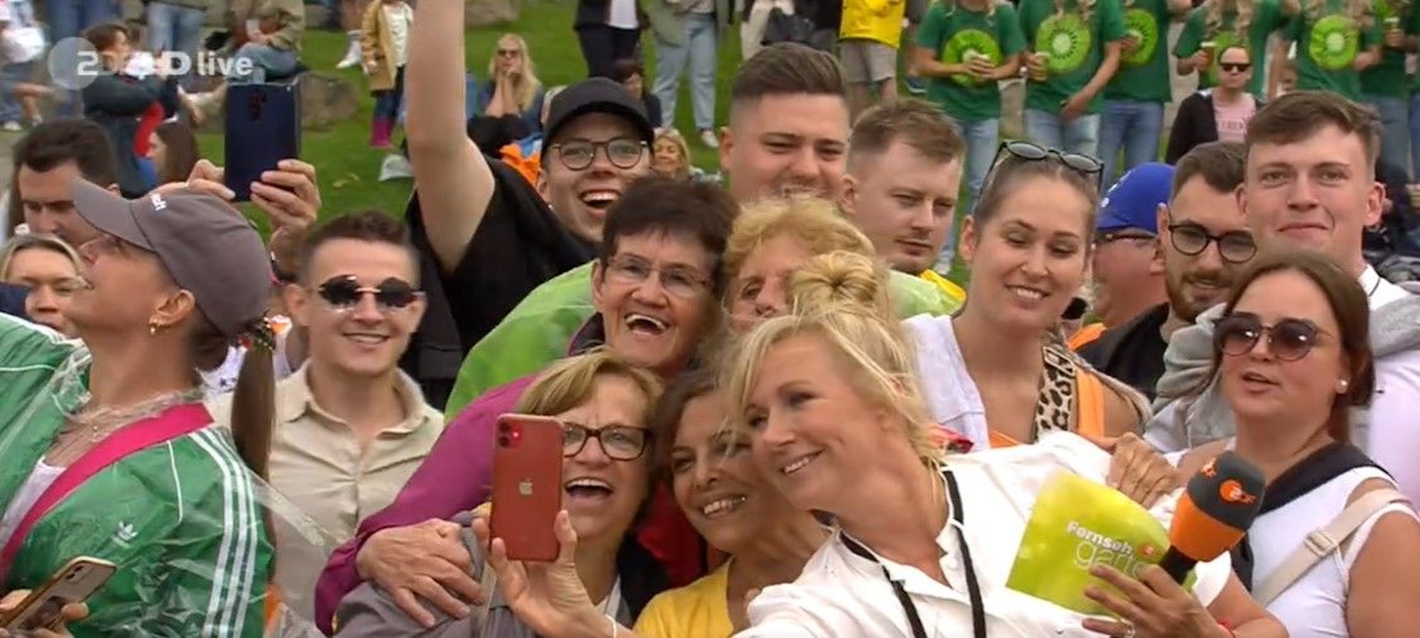 Moderatorin Andrea Kiewel schießt während der Sendung vom ZDF-Fernsehgarten Selfies mit ihren Fans, hier während der Sendung vom 30. Juni.