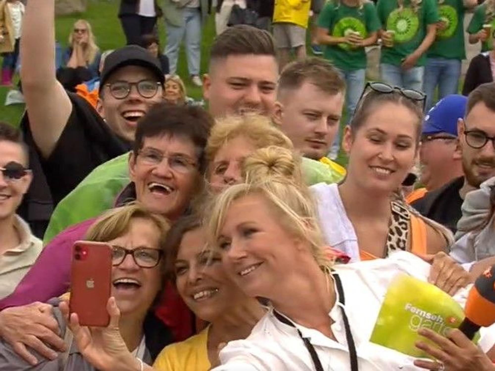 Moderatorin Andrea Kiewel schießt während der Sendung vom ZDF-Fernsehgarten Selfies mit ihren Fans, hier während der Sendung vom 30. Juni.