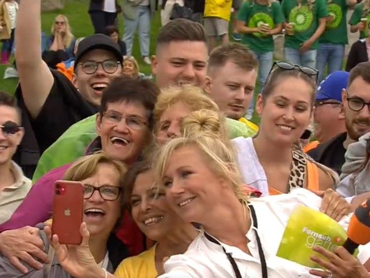Moderatorin Andrea Kiewel schießt während der Sendung vom ZDF-Fernsehgarten Selfies mit ihren Fans, hier während der Sendung vom 30. Juni.