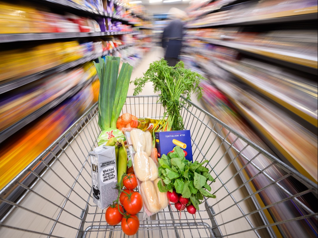 Ein mit Lebensmittel gefüllter Einkaufswagen wird durch einen Supermarkt geschoben, hier im August 2023 in Hannover.