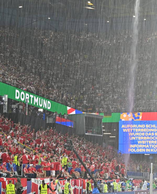 Der Regen strömt vom Dach des Dortmunders Stadions, auf der Anzeigetafel werden die Fans über die Spielunterbrechung informiert.