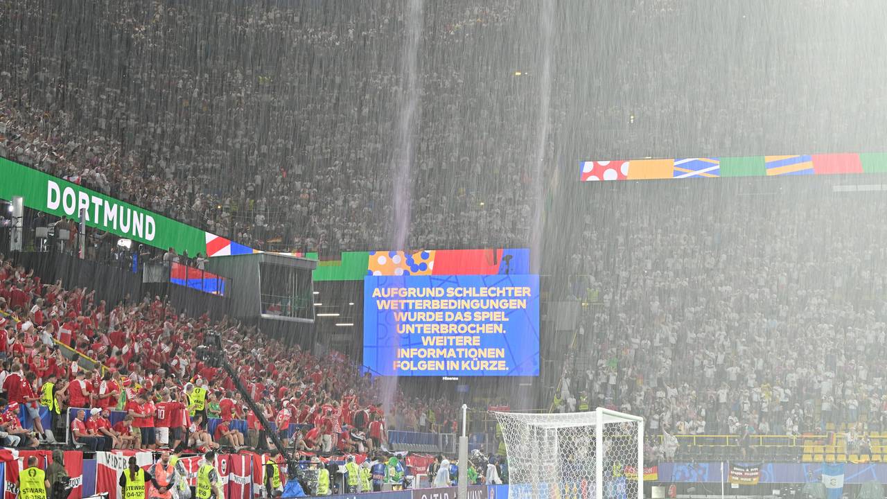 Der Regen strömt vom Dach des Dortmunders Stadions, auf der Anzeigetafel werden die Fans über die Spielunterbrechung informiert.