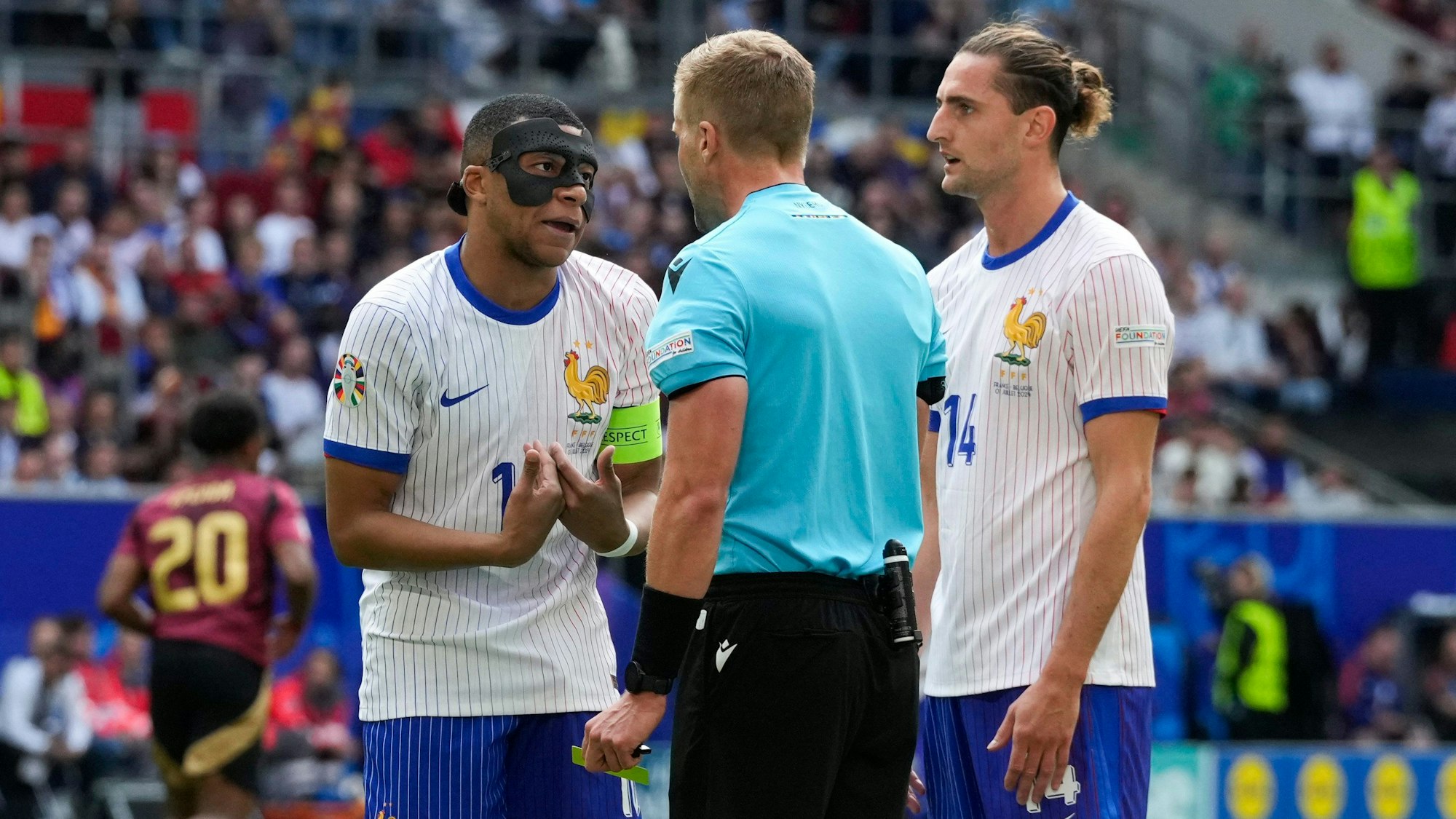 Kylian Mbappé und Adrien Rabiot beim EM-Spiel zwischen Frankreich und Belgien im Gespräch mit Schiedsrichter Glenn Nyberg.