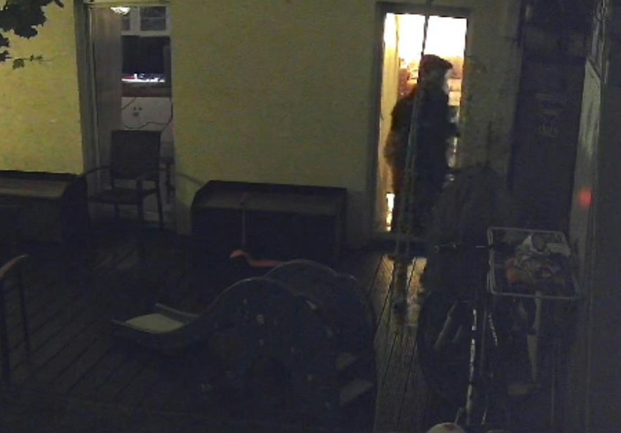 Ein Mann steht im Dunkeln auf einer Terrasse.