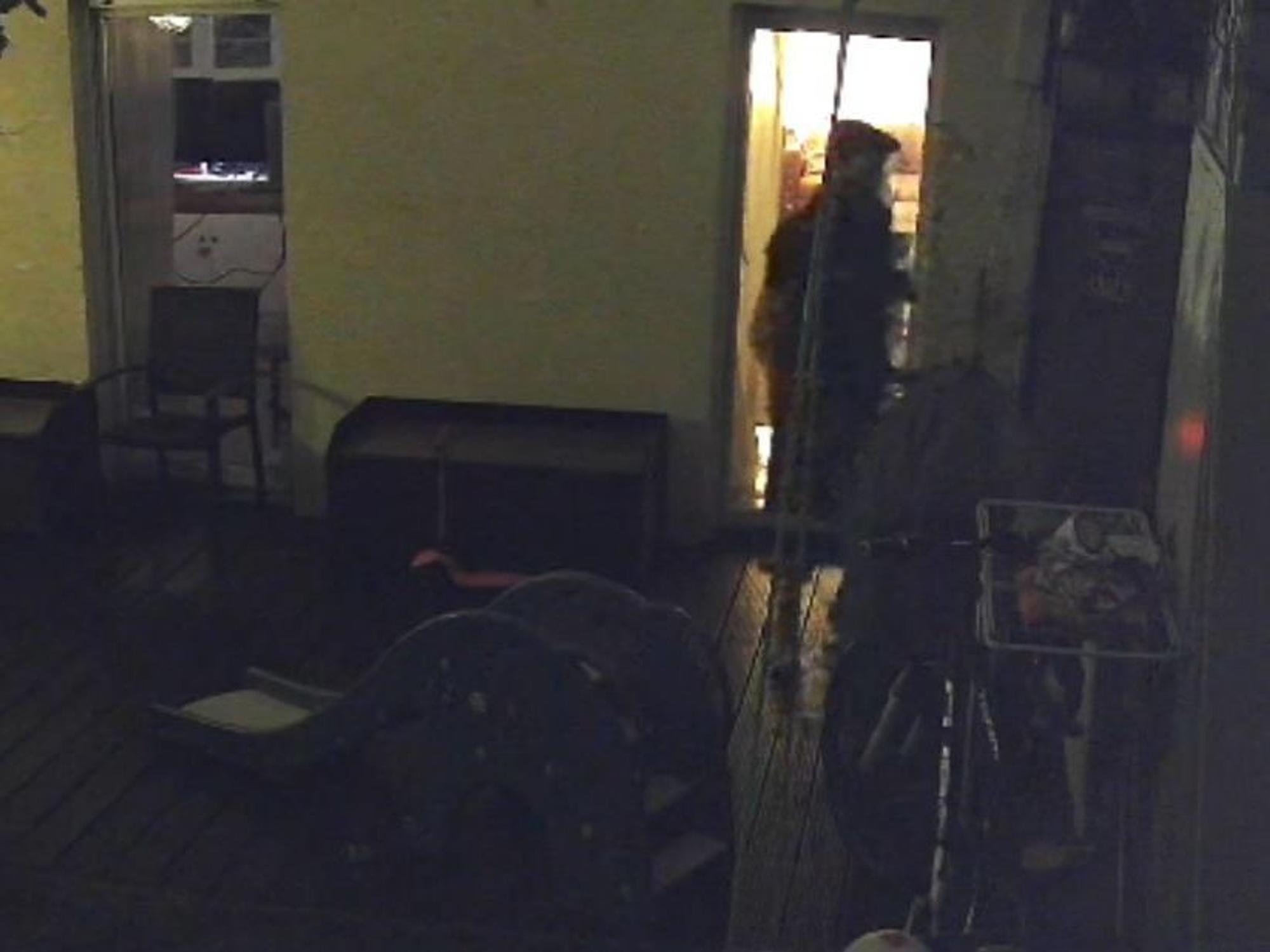 Ein Mann steht im Dunkeln auf einer Terrasse.