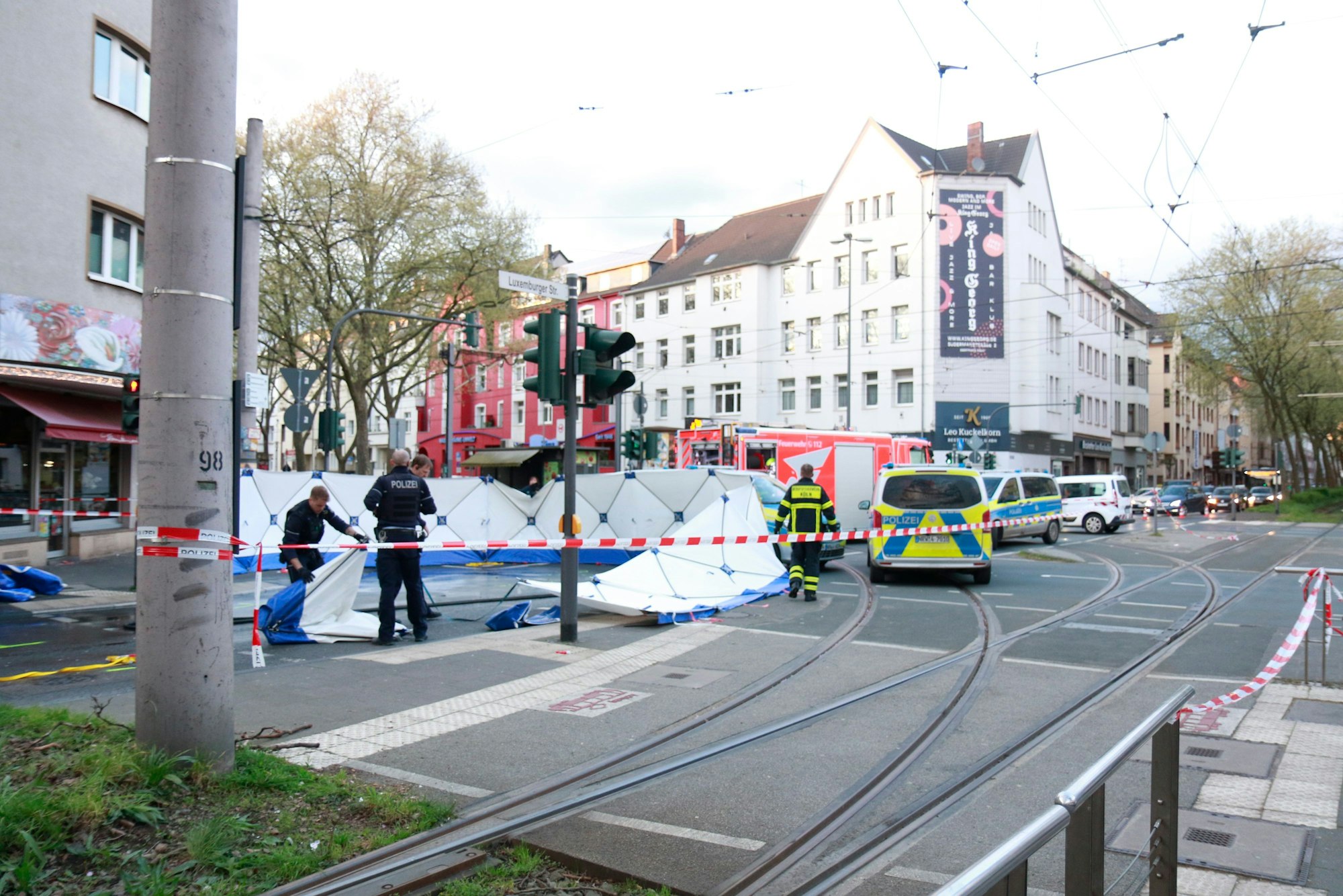 Polizei und Rettungsdienst stehen an einer Unfallstelle am Sülzgürtel in Köln.
