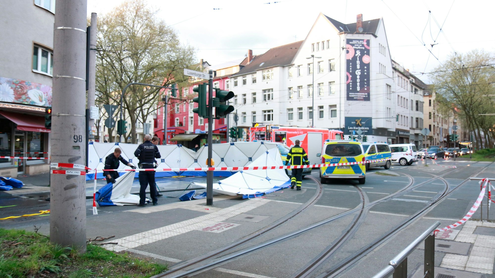 Polizei und Rettungsdienst stehen an einer Unfallstelle am Sülzgürtel in Köln.