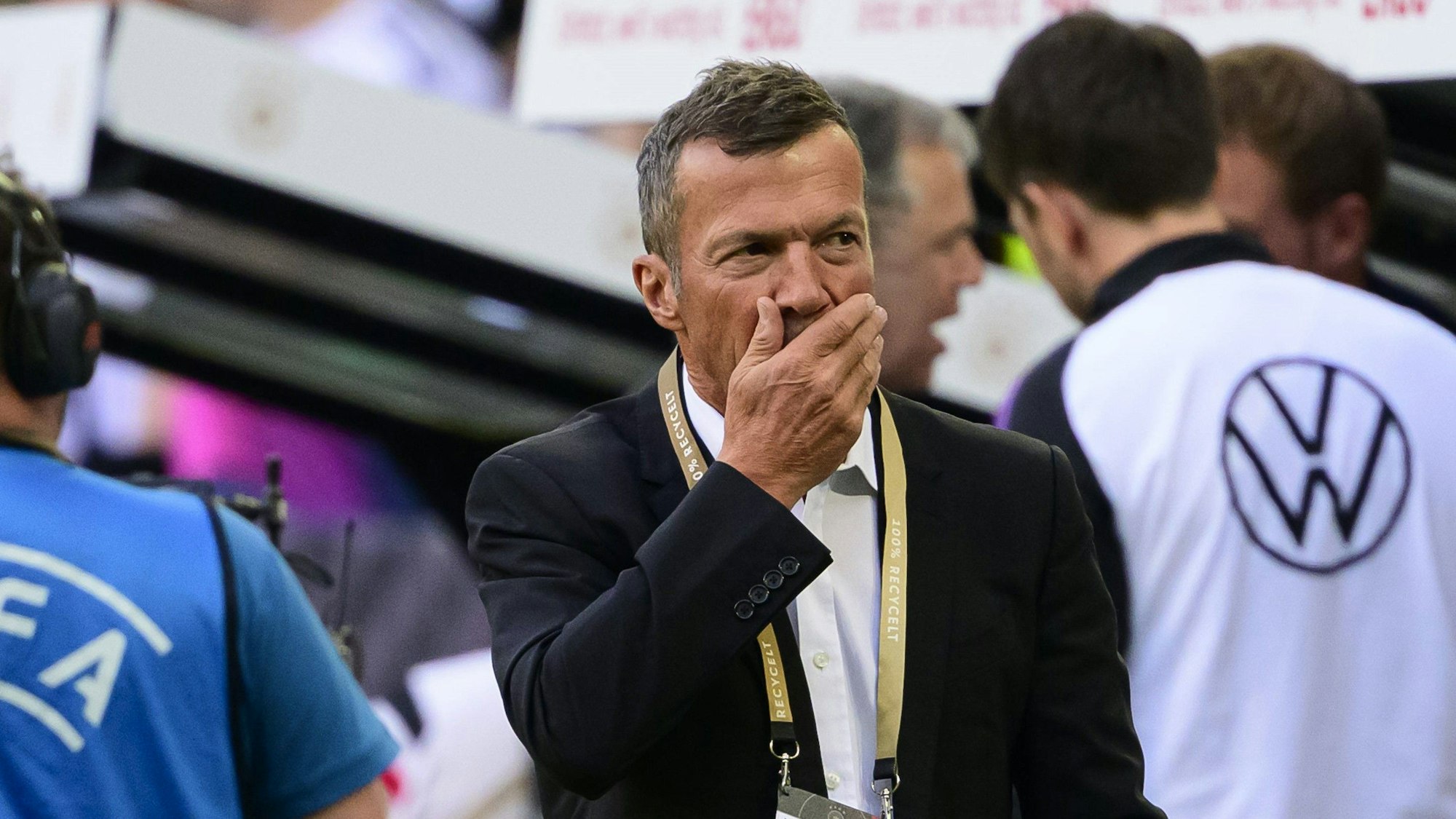 Lothar Matthäus hält sich die Hand vor den Mund.