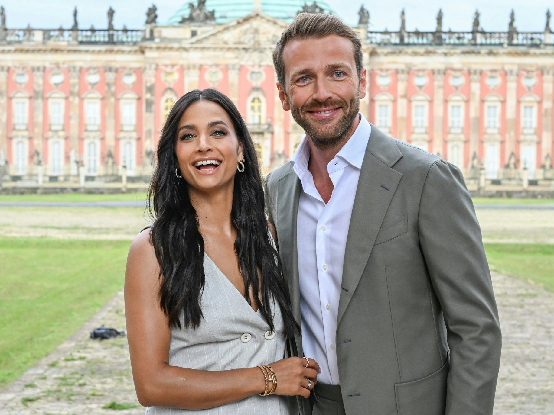 Amira Pocher und Christian Düren kommen zur Show des Labels Marc Cain in die Kolonnaden mit Triumphtor am Neuen Palais.