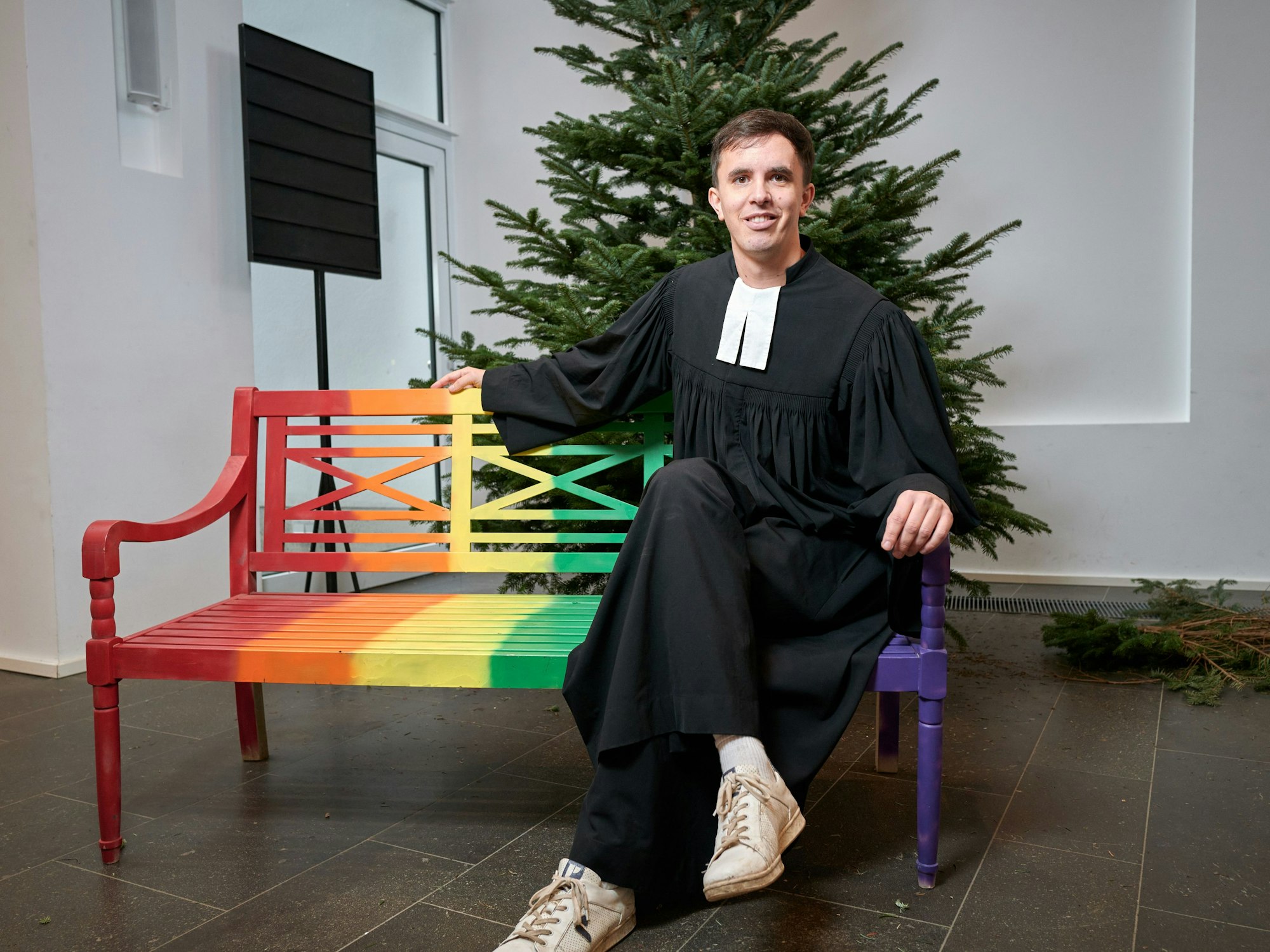 Tim Lahr sitzt auf einer Bank in seiner Kirche.