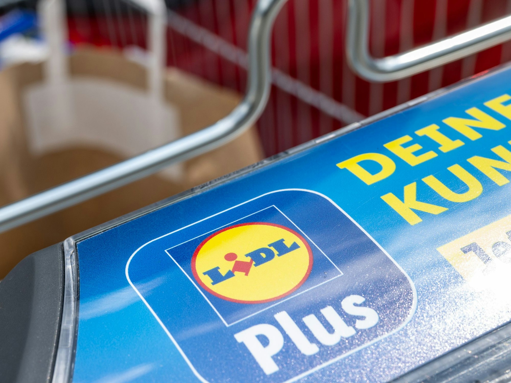 Ein Einkaufswagen mit dem Logo des Discounters Lidl steht am Kofferraum eines PKW in Leipzig.