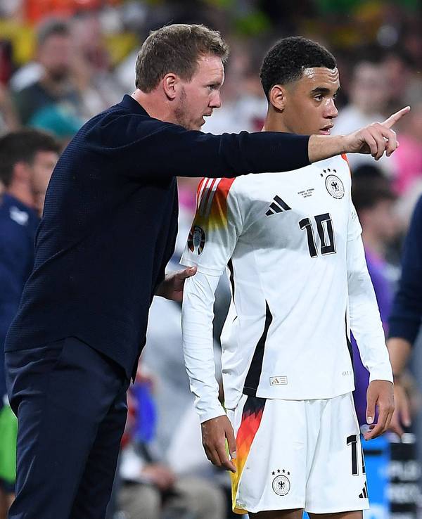 Bundestrainer Julian Nagelsmann gibt Jamal Musiala am Spielfeldrand Anweisungen.