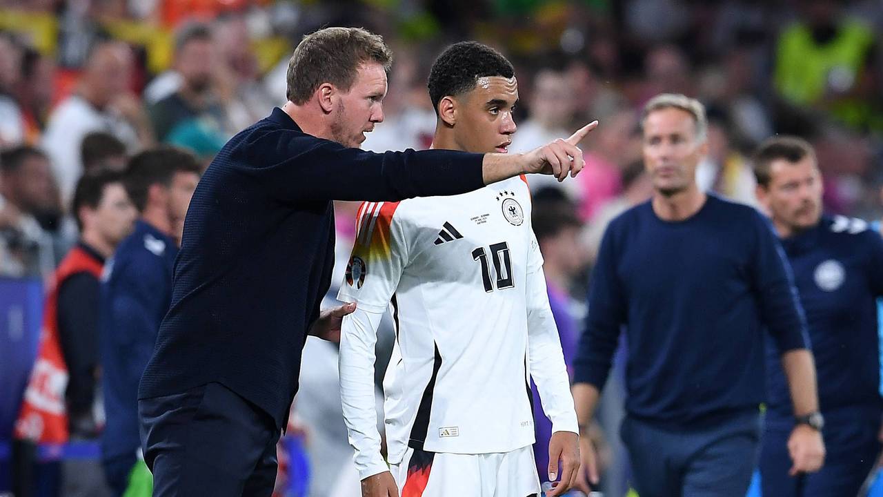 Bundestrainer Julian Nagelsmann gibt Jamal Musiala am Spielfeldrand Anweisungen.