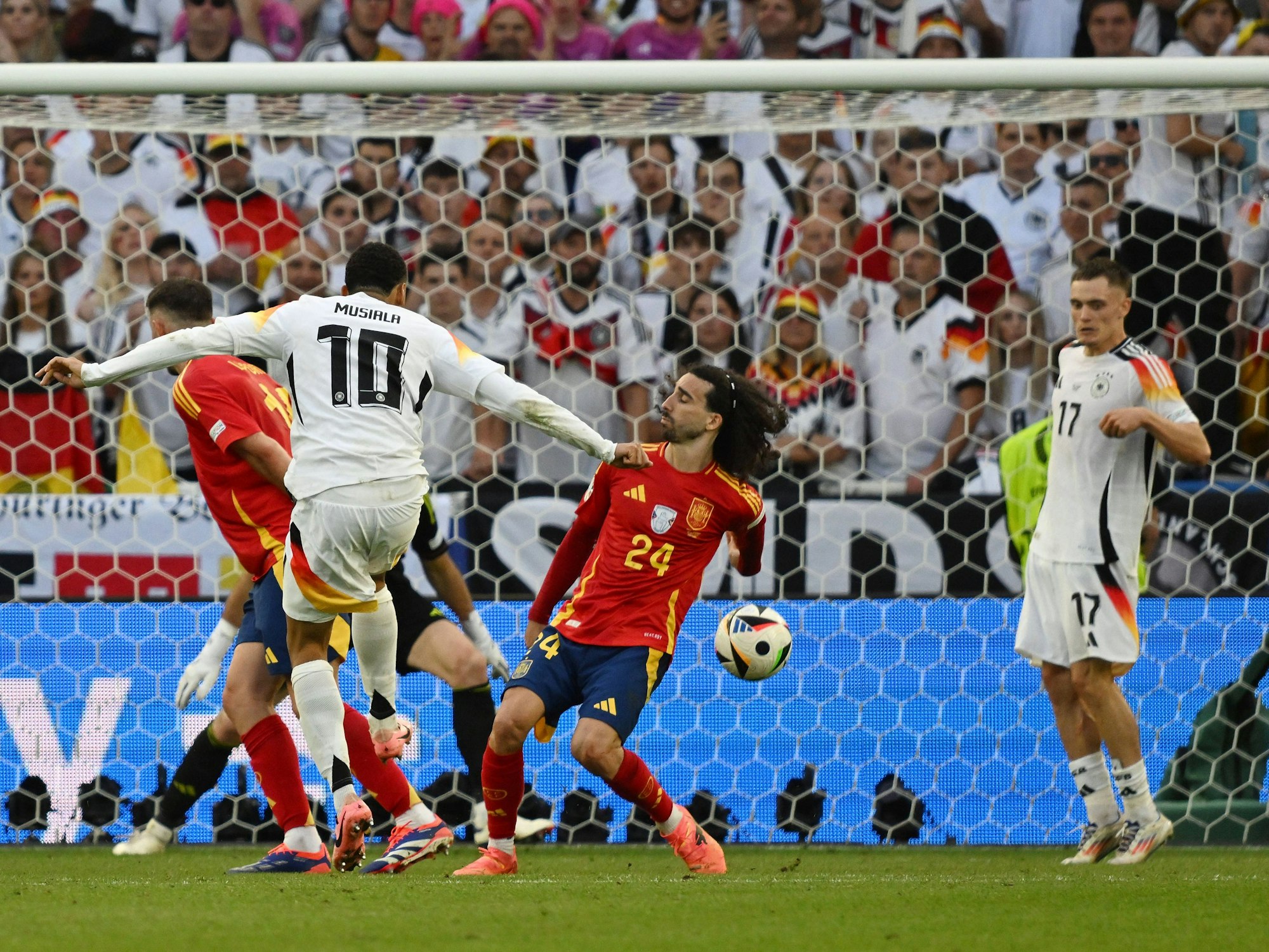 Jamal Musiala schießt und Marc Cucurella blockt den Ball mit der Hand.