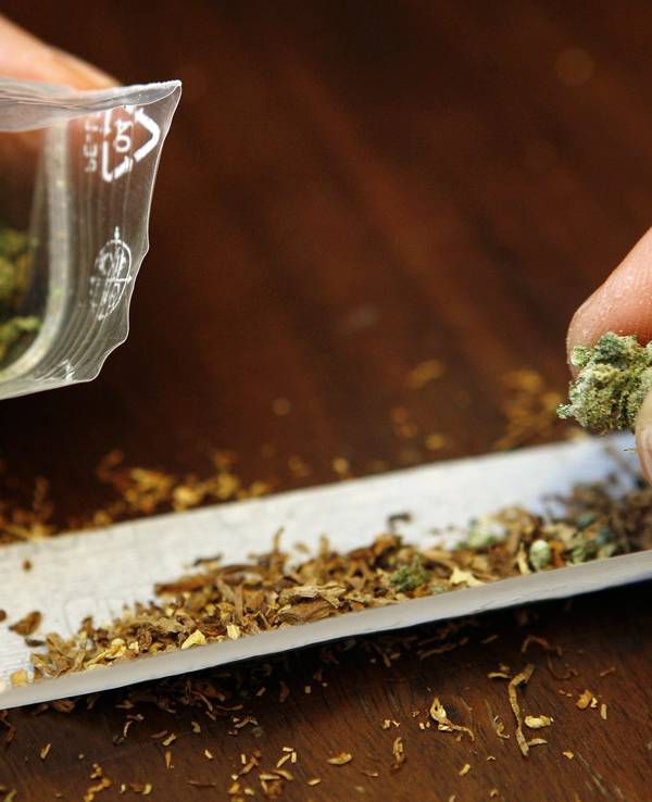 Ein Mann dreht sich einen Joint mit Marihuana (Symbolfoto).