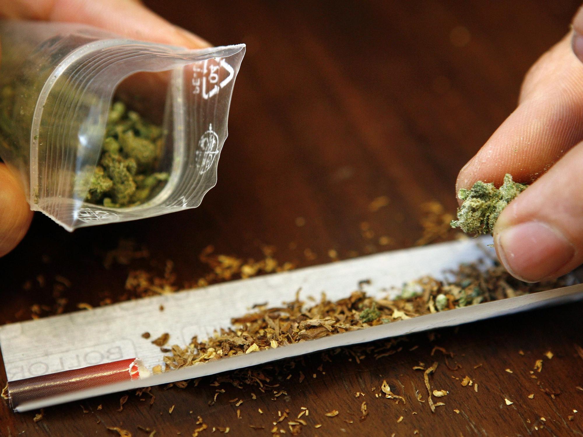 Ein Mann dreht sich einen Joint mit Marihuana (Symbolfoto).