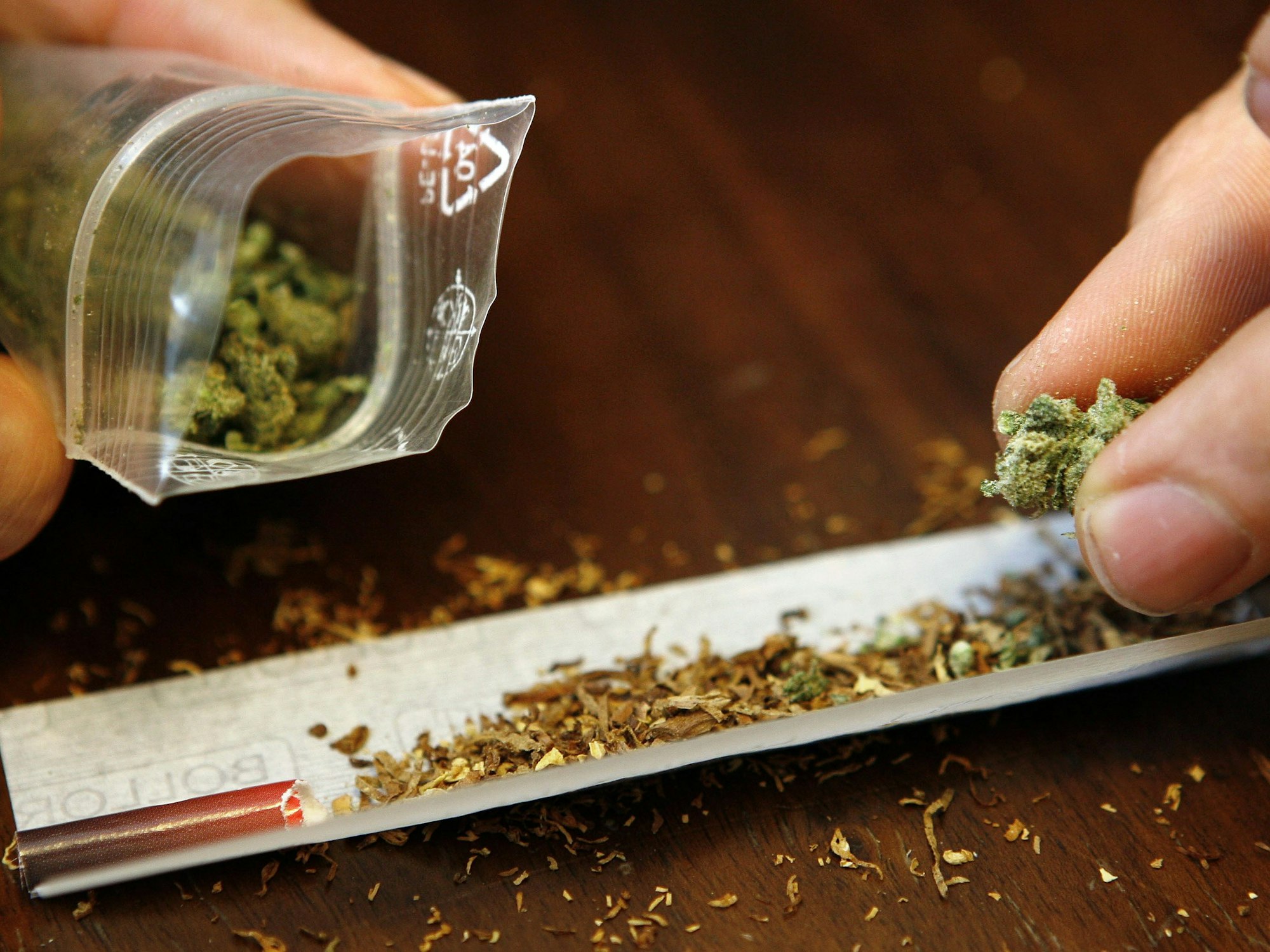 Ein Mann dreht sich einen Joint mit Marihuana (Symbolfoto).