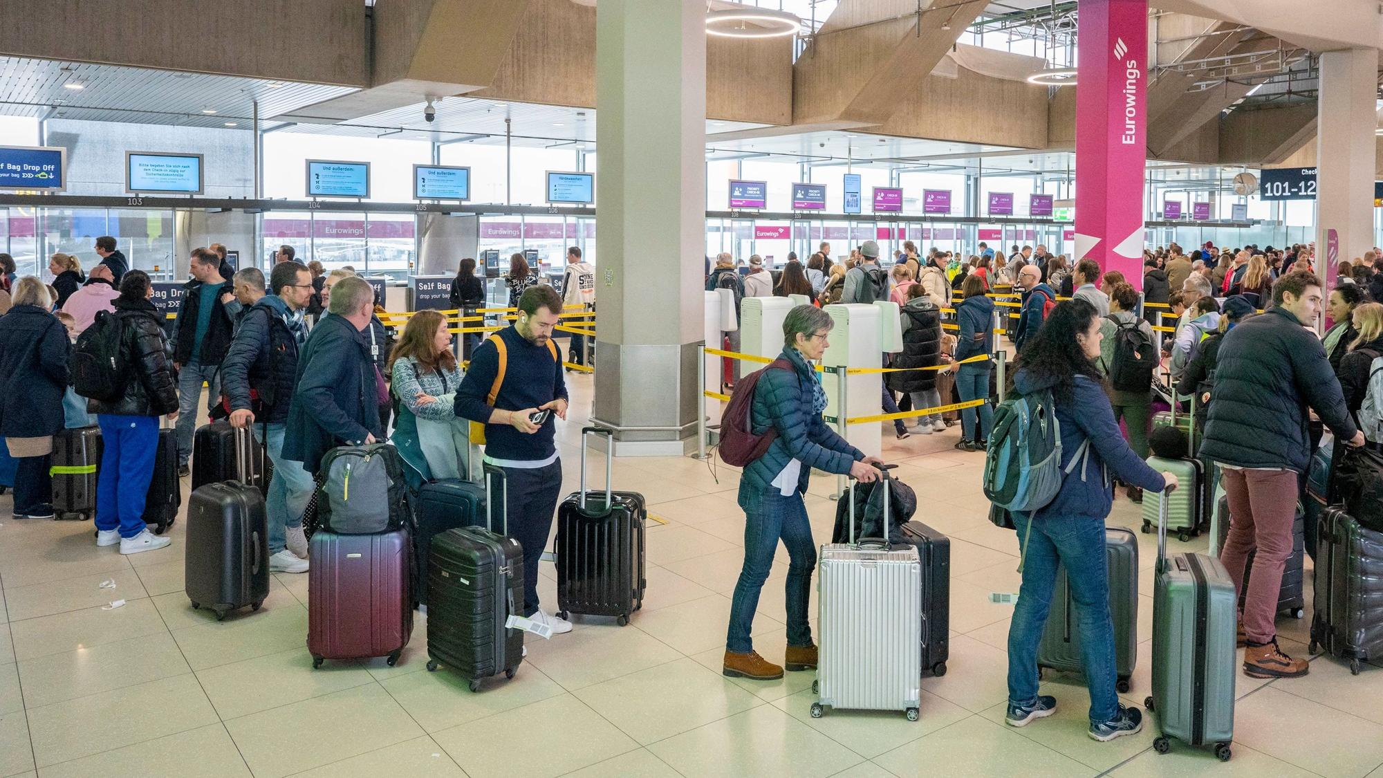 Am Flughafen checken viele Reisende zu ihrem Flug in den Urlaub ein.