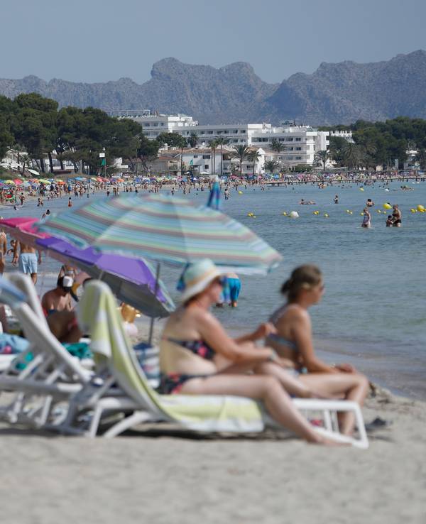 Viele Menschen genießen Sonne, Sand und Meer am Strand „Playa de Muro“ im Norden von Mallorca.