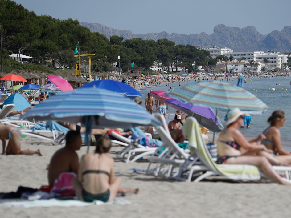 Viele Menschen genießen Sonne, Sand und Meer am Strand „Playa de Muro“ im Norden von Mallorca.