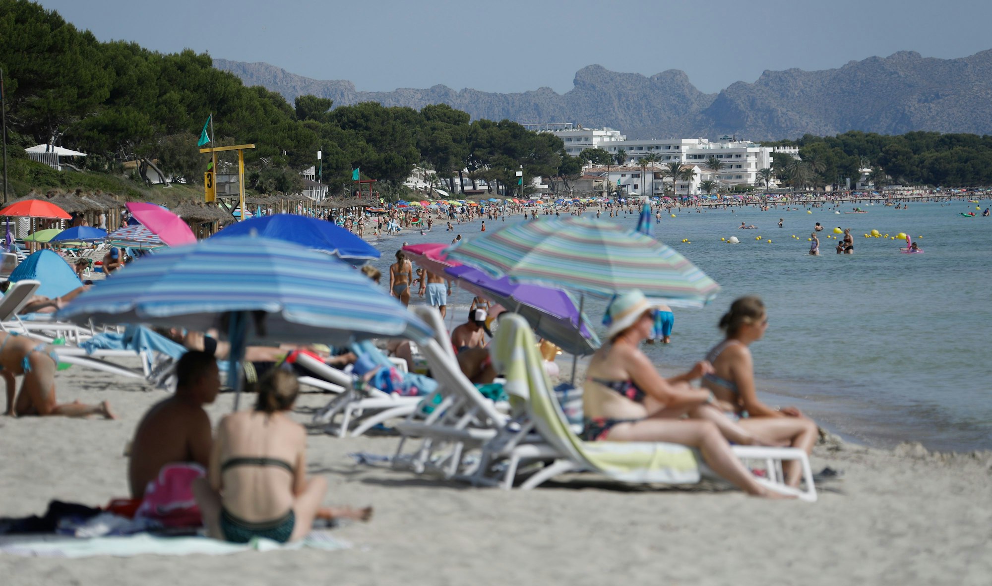 Viele Menschen genießen Sonne, Sand und Meer am Strand „Playa de Muro“ im Norden von Mallorca.