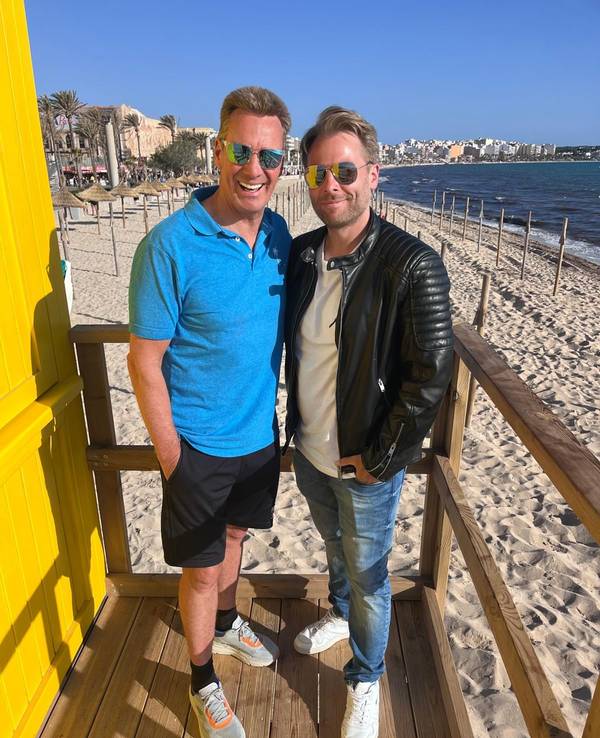 Jürgen Milski und DJ Aaron stehen auf einem Hochsitz an einem Strand auf Mallorca.