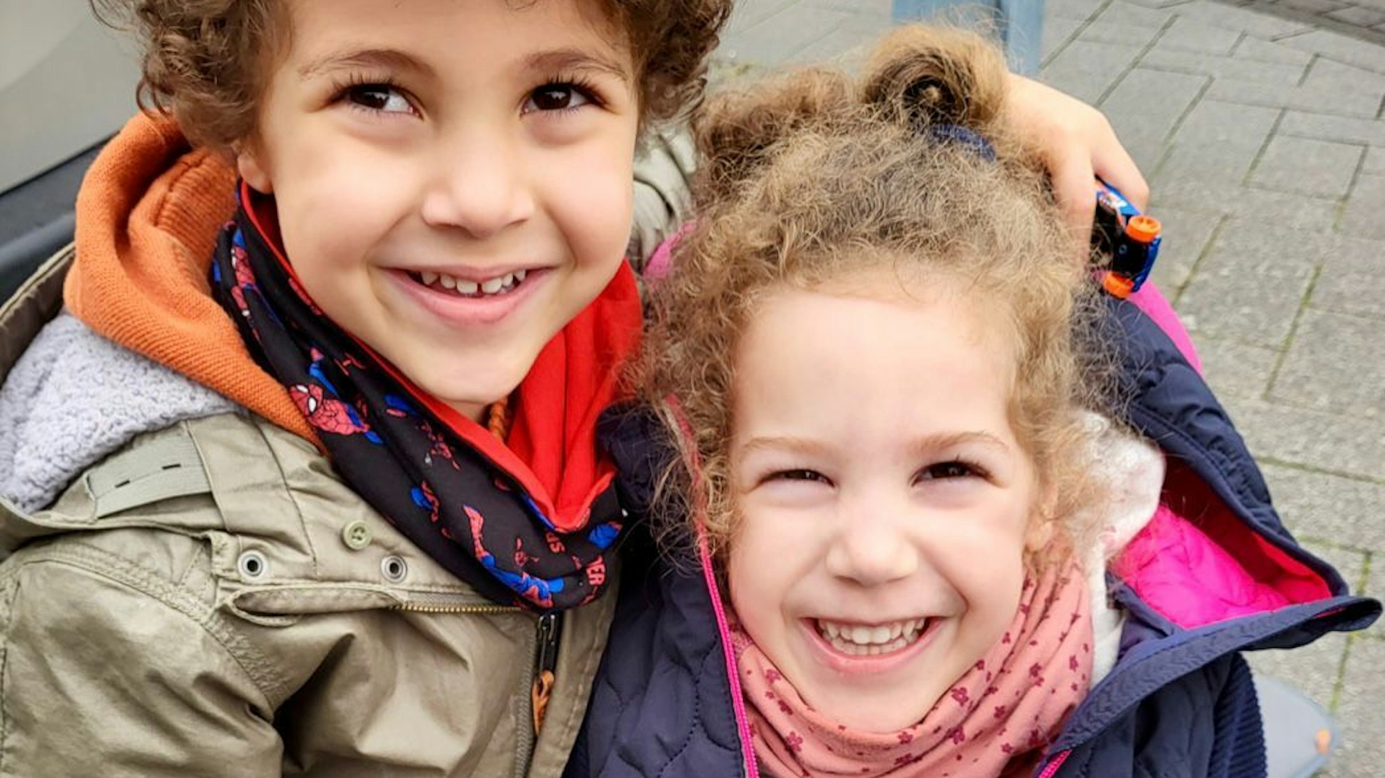 Carlotta (r.) und ihr Zwillingsbruder Charlie lachen in die Kamera.