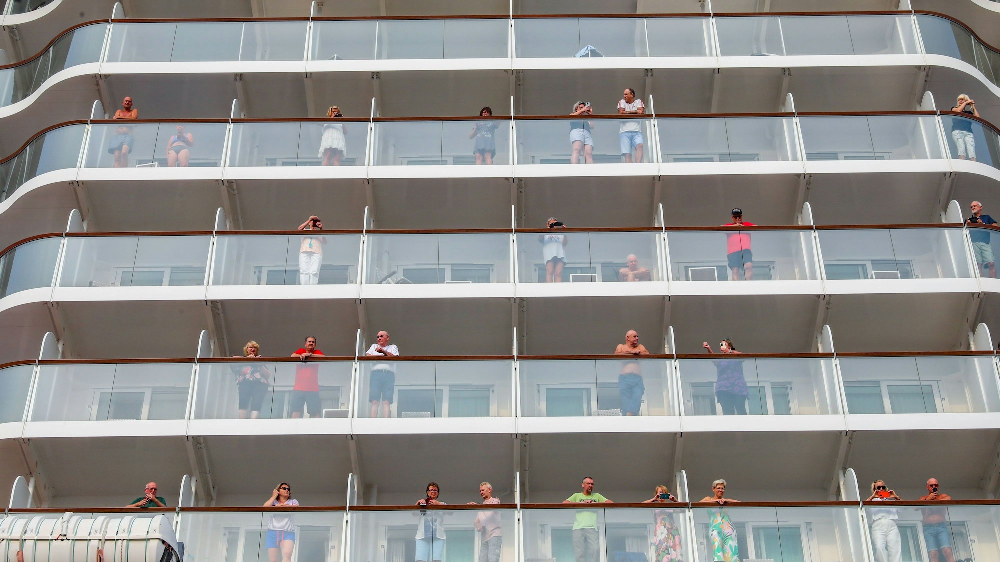 Menschen stehen auf den Balkonen der Kabinen.